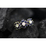 A sapphire and diamond triple cluster ring, designed as three central diamonds,