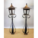 A pair of Arts and Crafts copper and iron pedestal lanterns,