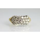 A three row diamond ring, the three rows of brilliant cut diamonds, each claw set in white metal,