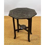 An Edwardian carved oak folding table, possibly Irish, the top carved with a swirl of leaves,