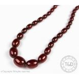 A 'cherry' amber bead necklace. the graduated bead necklace with screw bead clasp, gross weight 64.