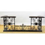 A wrought iron and brass club fender, with tan leather corner seats and foliate detailing,