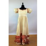 A early 19th century regency style evening dress of cream figured silk,
