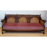 A 1920's carved walnut three piece bergere suite, comprising three seater settee and two chars,