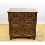 A 1920's oak chest, with two short drawers and two fielded panelled drawers, on stile feet,