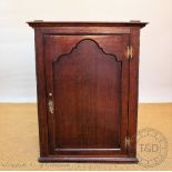 A George III oak hanging corner cabinet,