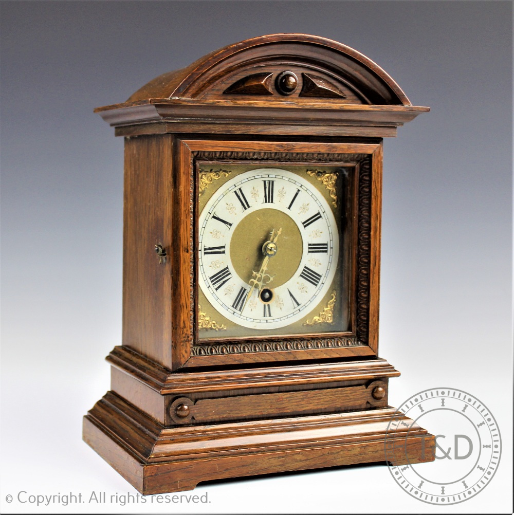 An Edwardian carved oak eight day mantel clock,