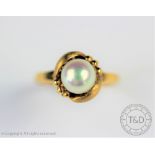 An untested pearl set dress ring, the central pearl within a foliate surround with matt finish,