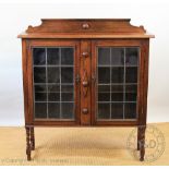 A 1920's oak two door display cabinet, with lead glazed doors,