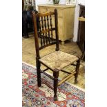 A set of four stained oak and beech spindle back dining chairs, with rush seats,