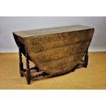 An 18th century style oak gate leg table, on barley twist and block legs,