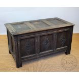 A George III oak coffer, with panelled top and front, the front with later carved floral detailing,