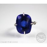 A blue stone set dress ring, the large central blue stone of rounded rectangular,