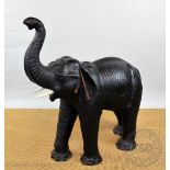 An early 20th century leather model of an elephant, with faux tusks,