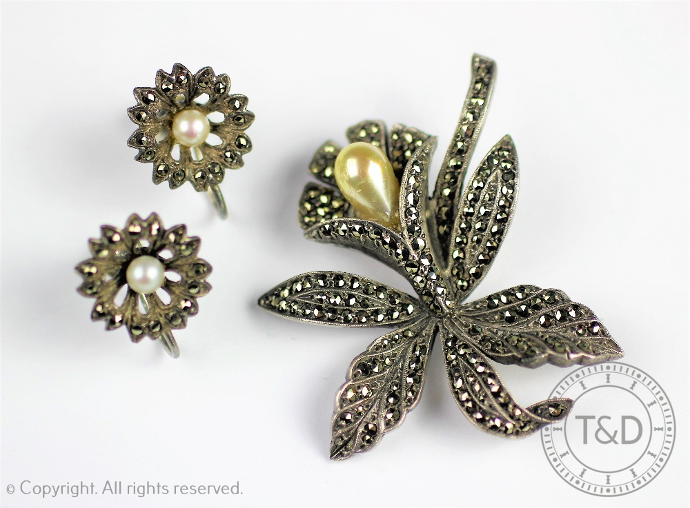 A silver and marcasite set floral brooch in the form of an orchid and a matched pair of marcasite