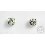 A pair of diamond solitaire earrings,