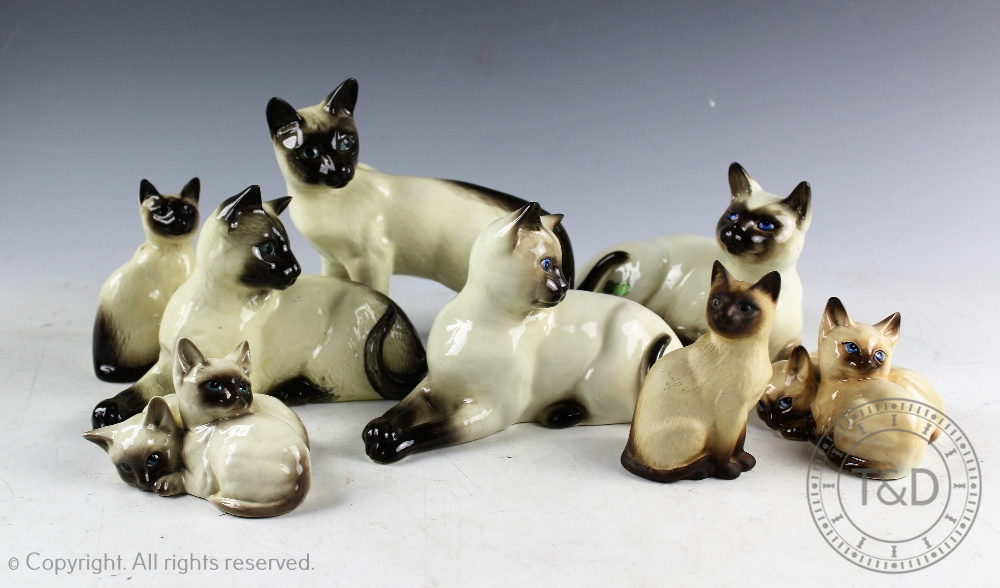 A collection of eight Beswick Siamese cats, comprising; seated,