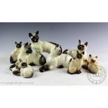 A collection of eight Beswick Siamese cats, comprising; seated,
