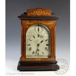 A late Victorian inlaid mahogany eight day mantel clock, with silvered Roman numeral dial,