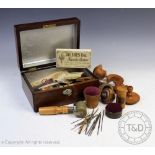 A collection of 19th century and later treen sewing tools, pin cushions and boxes,