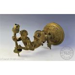 A late Victorian cast brass wall light, modelled as a merman supporting a torch,