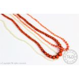 A graduated coral coloured bead necklace,