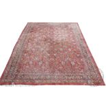 A machine woven carpet, worked with a floral design against a red ground,