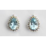 A pair of blue topaz set earrings, each pear shaped stone claw set in yellow metal,