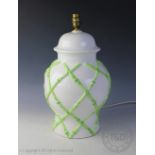 A contemporary baluster table lamp base, with applied green bamboo sprigs against a white ground,