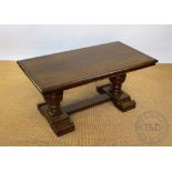 An oak coffee table, on carved baluster legs,