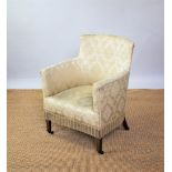 An Edwardian mahogany salon tub chair, with floral yellow upholstery, on tapered legs,