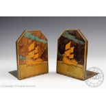 A pair of Art Deco painted book ends, each decorated with a vessel at sea in full mast,