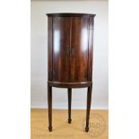 A George III bow front oak corner cabinet, on later stand,
