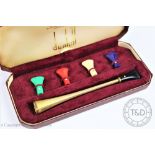 A Dunhill 9ct gold cheroot holder with engine turned decoration and set of five coloured