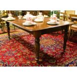 A Victorian mahogany dining table, with one spare leaf, on turned baluster legs,