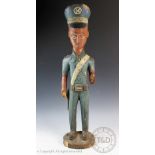 A large African Baule colonial art carved and painted figure of a policeman,