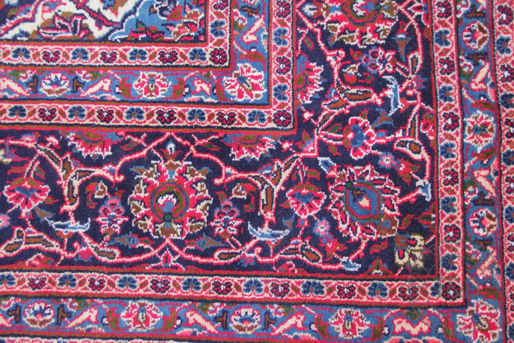 A large Persian Kashan wool carpet, worked with an all over floral design against a red ground, - Bild 2 aus 3