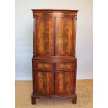A reproduction walnut cocktail cabinet, with two doors above two drawers and two cupboard doors,