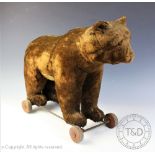 A Steiff pull-along bear, early 20th century, covered in dark brown plush, black eyes,