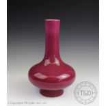 A Chinese porcelain pink monochrome vase, of swollen bottle form, simply glazed to the exterior,