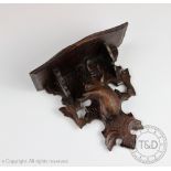 A Black Forest carved wall bracket/shelf, carved with deer and foliate suport,