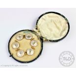 A cased set of six mother of pearl, white enamelled and yellow metal buttons,