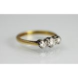 A three stone diamond ring, the three graduated diamonds, each claw set in white metal,