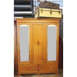 An Edwardian inlaid satinwood wardrobe, with a panelled and a mirrored door, above two drawers,