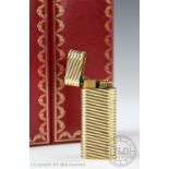 An 18ct gold Cartier lighter, the tri-colour gold case with wrythen detail,