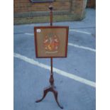 A firescreen with square tapestry panel, on pole and three legs. 119cm high.