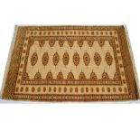 A cream ground rug with red and green pattern. 192 x 130cm.
