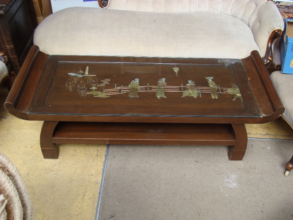 A glass inset two tier coffee table featuring a Chinese scene made of brass, copper and white