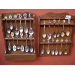 A collection of souvenir spoons in two display racks.