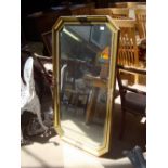 A large wall mirror with gold painted frame and bevelled glass. 130 x 72 cm.